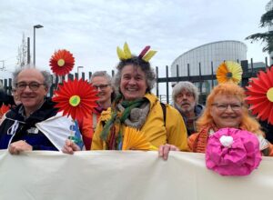 FILE PHOTO: Supporters of the Senior Women for Climate Protection association hold paper flowers and a banner outside the European Court of Human Rights in Strasbourg