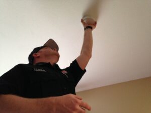 City of Monroe's Fire Commander Scott Smiley installs a smoke detector for a homeowner in a previous year. The American Red Cross seeks volunteers to install smoke alarms in Monroe County on May 1.