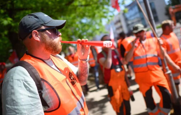 Construction workers take part in a strike at a pipeline construction site in the Hanover region. Julian Stratenschulte/dpa