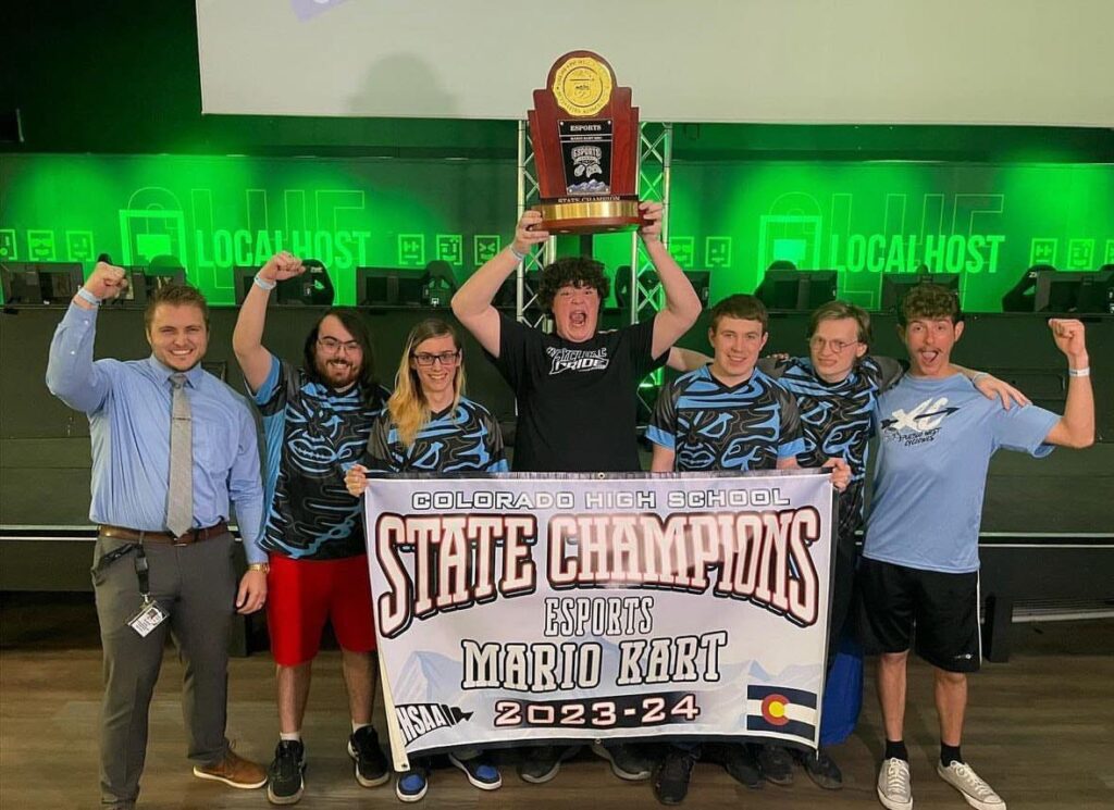 Cyclones coach Curtis Dunford (left) celebrates a Mario Kart state championship win with student competitors Alexander Price, Austin Gill, Bradley Johnson, Ayres Ritchey, Jesse Wardle and Mason Stanley.