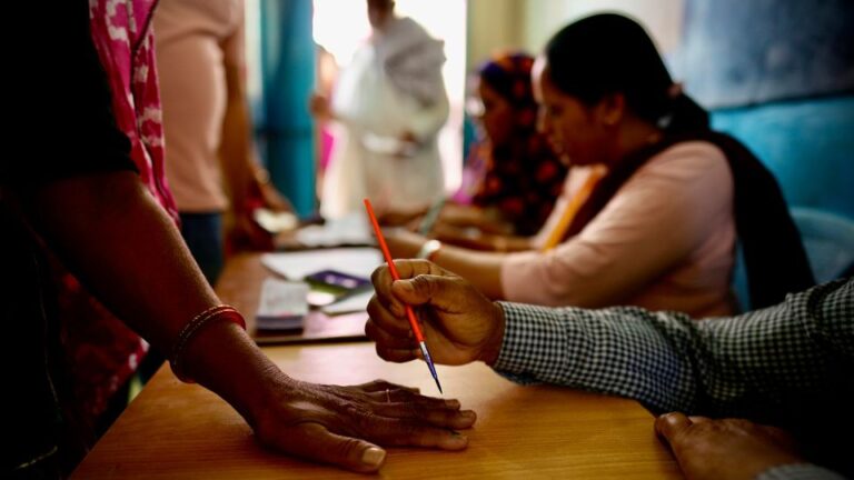 An official in Neemrana, India, paints a mark on the index finger of a woman with indelible ink before she casts her vote during the first round of polling in India's national election. - Manish Swarup/AP