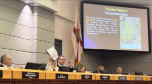 Ormond Beach City Commissioner Susan Persis holds up a report that Tomoka Oaks resident Carolyn Davis compiled on the community