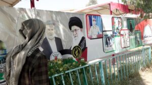 A Yemeni man walks next to a billboard with images depicting the Houthi leader Abdul-Malik Badreddin al-Houthi, Lebanon Hezbollah leader Hasan Nasrallah, and Yahya Sinwar, the Hamas military leader in the Gaza Strip, displayed on a street in solidarity with Palestinians on 10 June 2024, in Sana'a