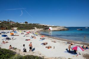 Tourists are flocking to Spain in record numbers, such as these seen sunbathing on the island of Menorca, giving the economy a huge boost (Jaime REINA)